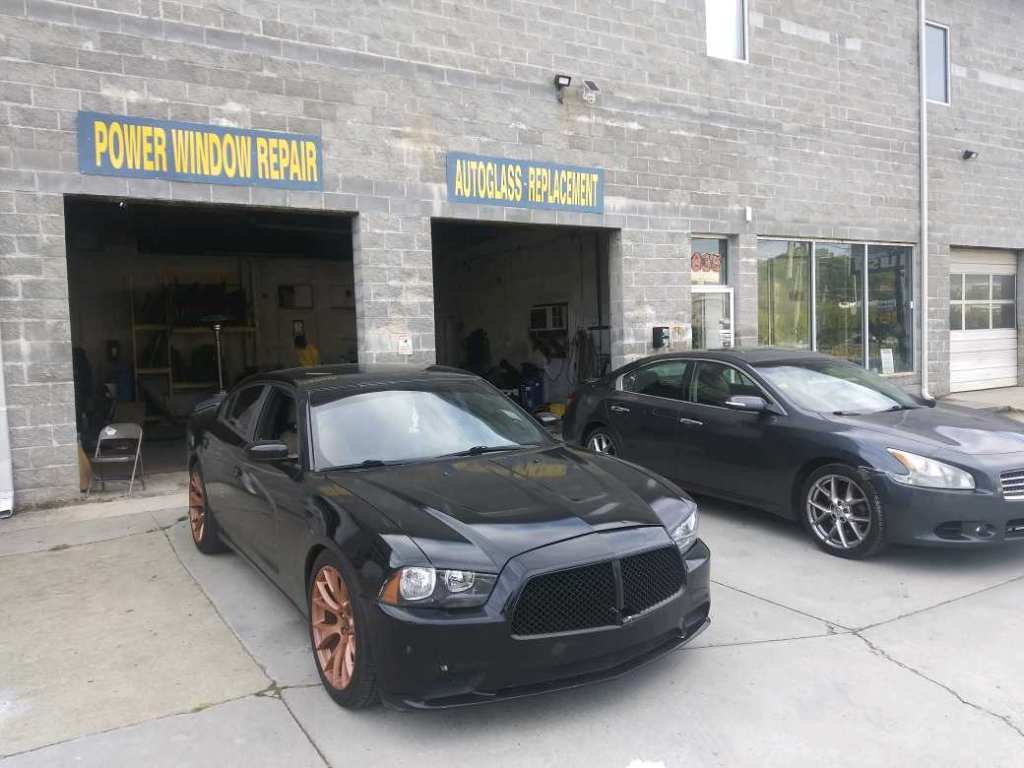 Two black cars parked outside the garage